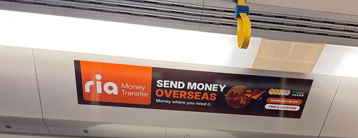 Close-up of the RIA Money Transfer ad inside a train carriage